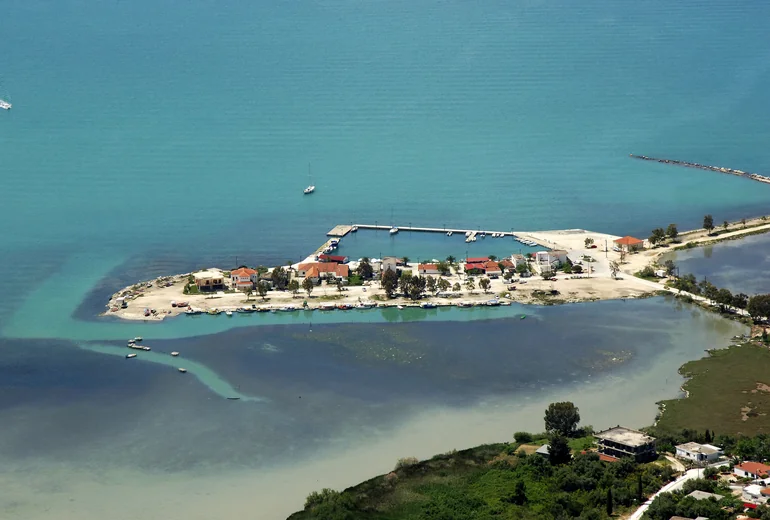 Greek island bay with anchored catamaran