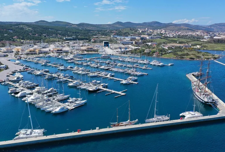 Aerial of Lavrion marina with rows of moored sailing yachts and tall ship