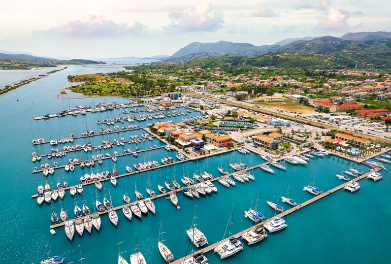 Aerial of Lefkada town marina pontoons packed with charter yachts