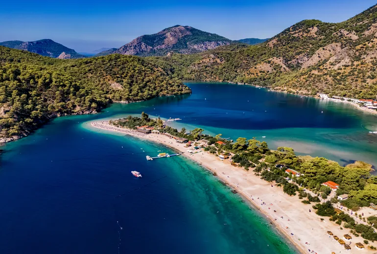 Aerial of Oludeniz Blue Lagoon sand spit, beach and forested mountains