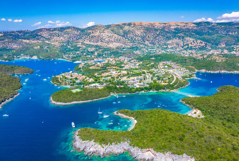 Aerial of Sivota islet-dotted coastline with anchored yachts and resort village