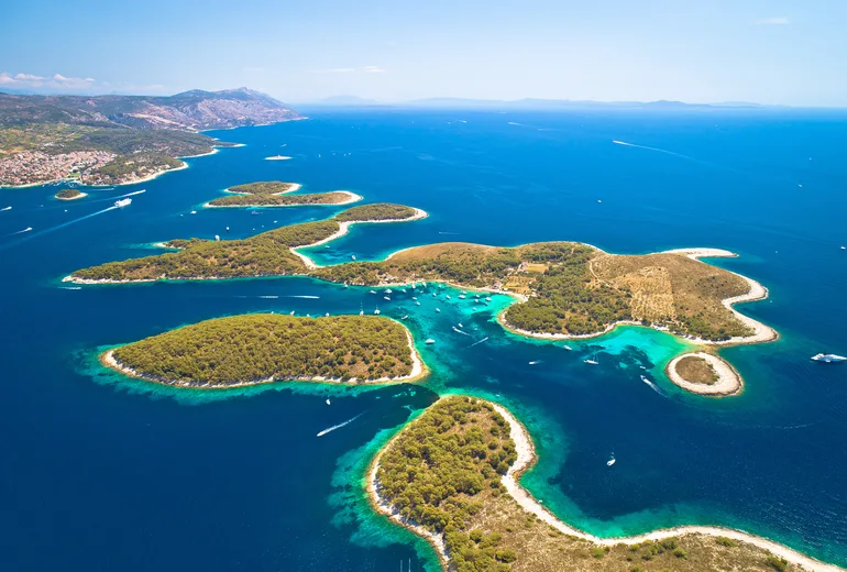 Aerial of the turquoise Pakleni island channels dotted with moored yachts near Hvar, Croatia