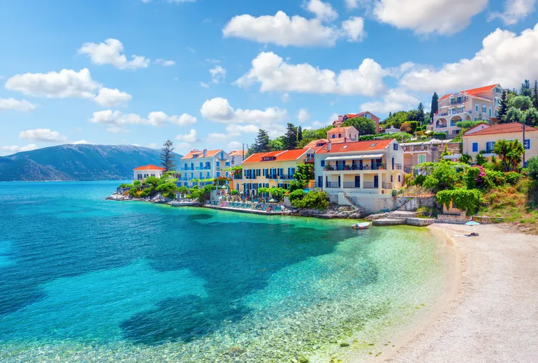 Pastel waterfront houses above clear shallows, Fiskardo, Kefalonia