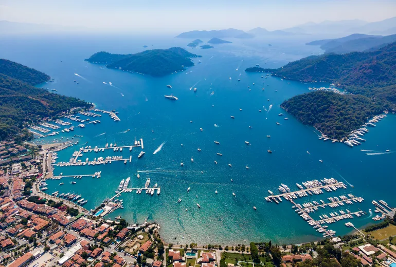 Sweeping aerial of Gocek bay, marinas full of yachts, town and pine islands, Turkiye