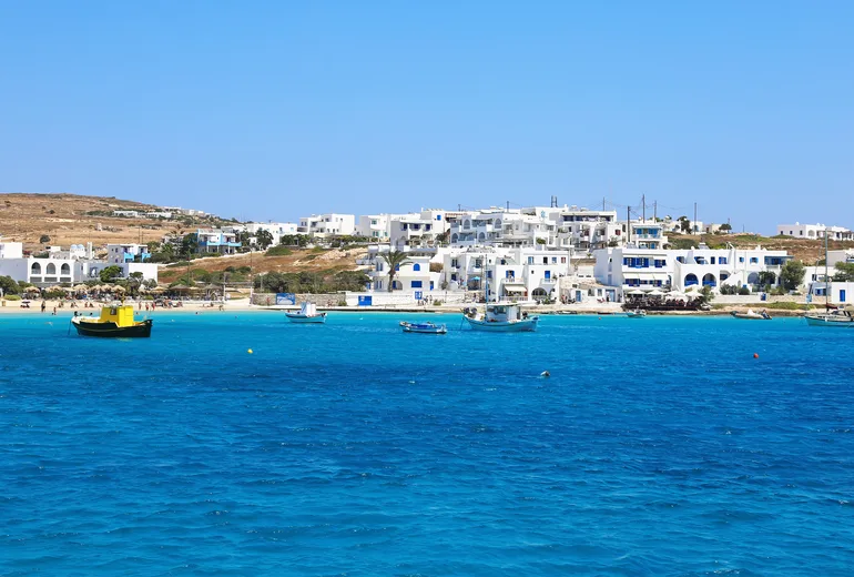 Whitewashed island village above a sandy bay in Greece