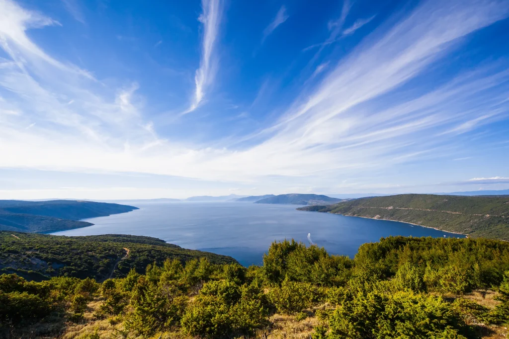 Hilltop panorama of green island slopes and wide blue sea channel